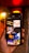 A hand is holding a smartphone displaying a search result for 'wedding' on its screen. The screen shows images related to weddings, such as rings, flowers, and wedding attire. The background features a warm, blurred ambiance with yellow and red lights, hinting at an indoor setting.