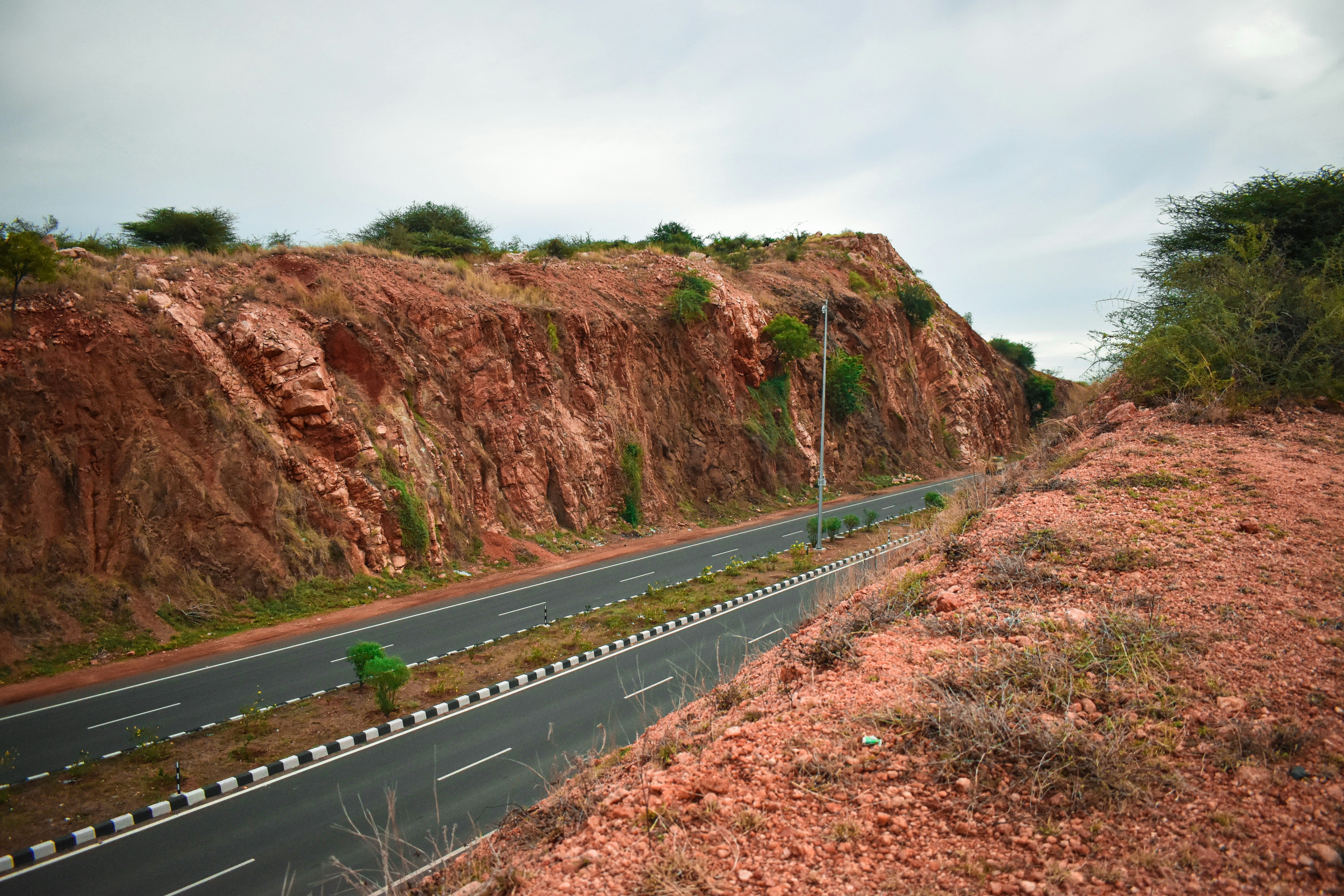 a road with a hill and trees