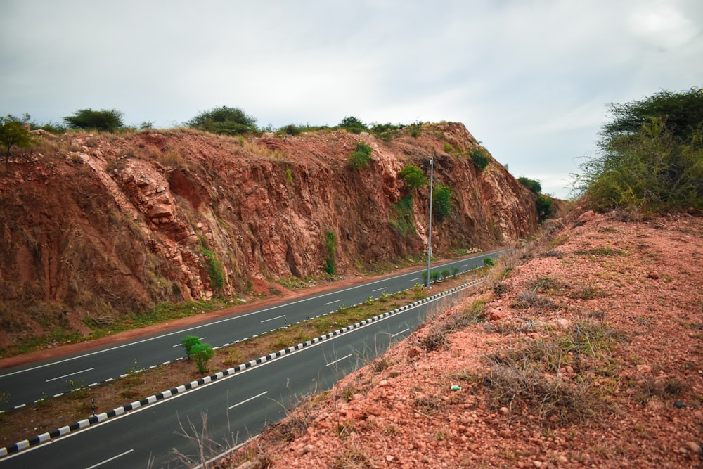 uma estrada com uma colina e árvores