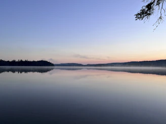 Close-up of gentle ripples on a quiet lake reflecting the sky at dawn.