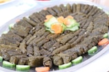 A beautifully arranged tray of stuffed grape leaves and tabbouleh salad.