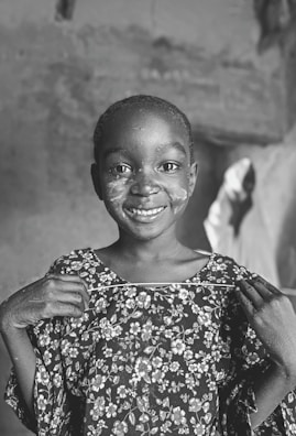 Close-up of a smiling child holding a vibrant craft kit from toymi.