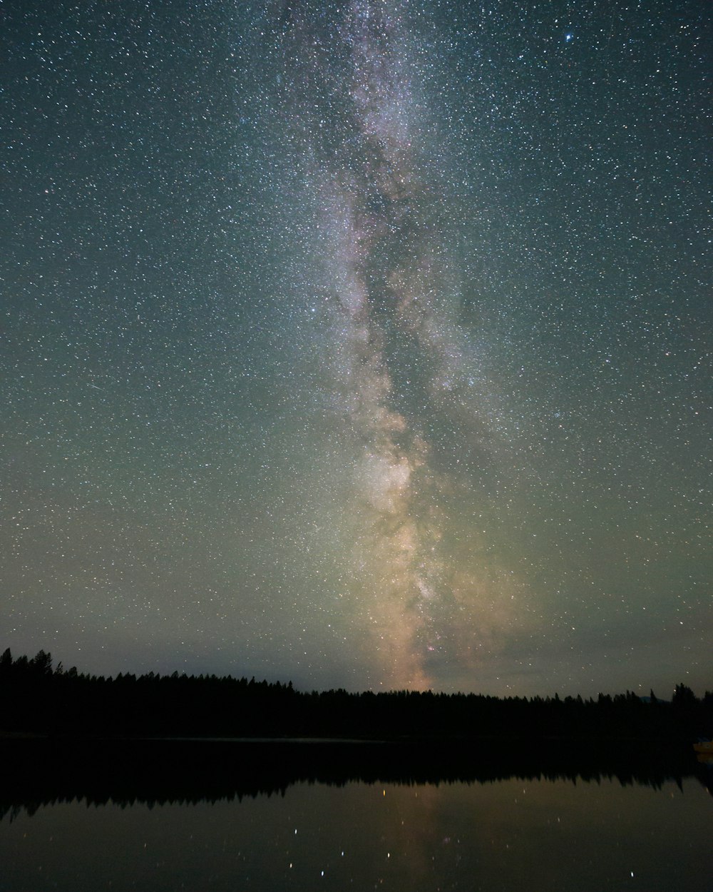 a starry night sky over a lake