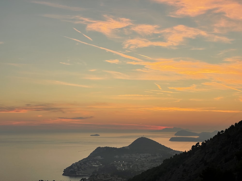 a view of a city and the ocean from a hill