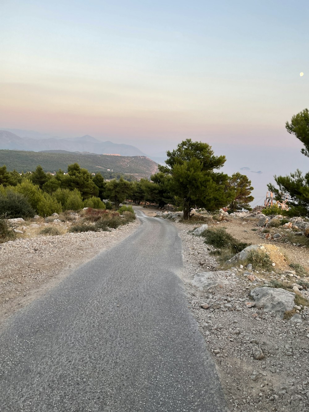 a road with trees and hills on the side