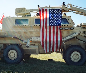 a military vehicle with a flag on the back