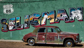 a car parked in front of a wall with art