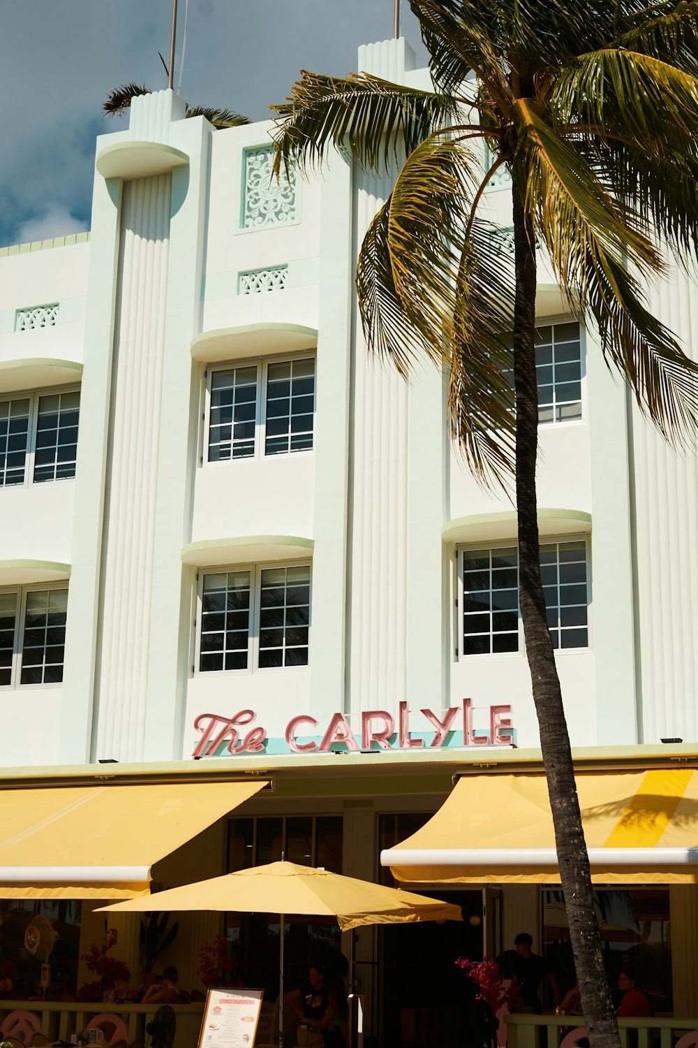 a building with palm trees and a sign on it