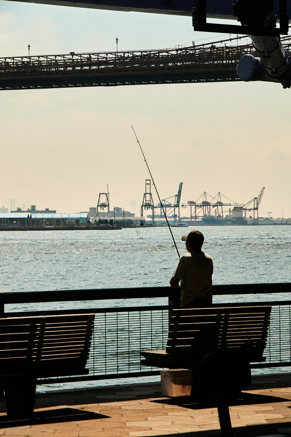 a person sitting on a bench looking at a large body of water