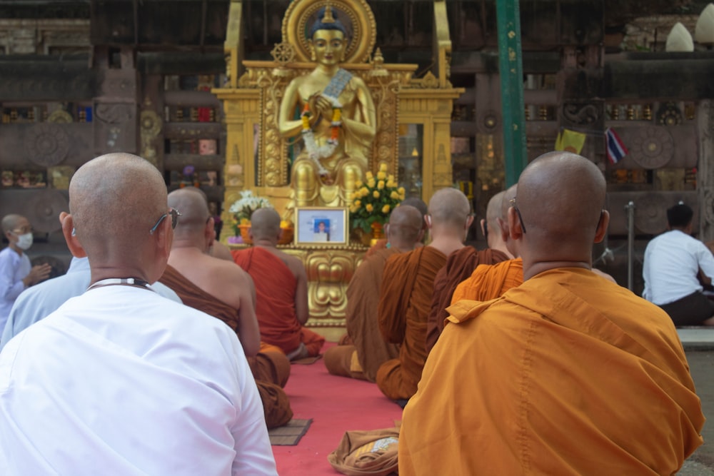 a group of people sitting in a room with a golden statue