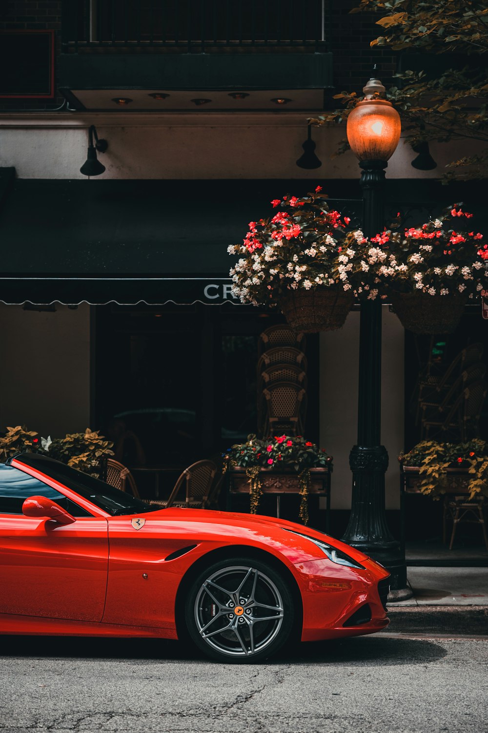 a red sports car parked in front of a building with a lamp post