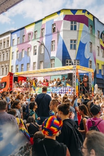 a crowd of people in front of a building with colorful windows
