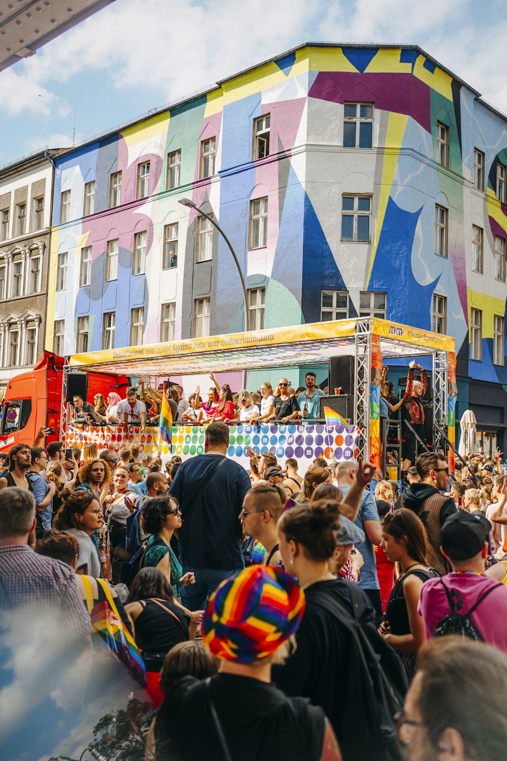 a crowd of people in front of a building with colorful windows