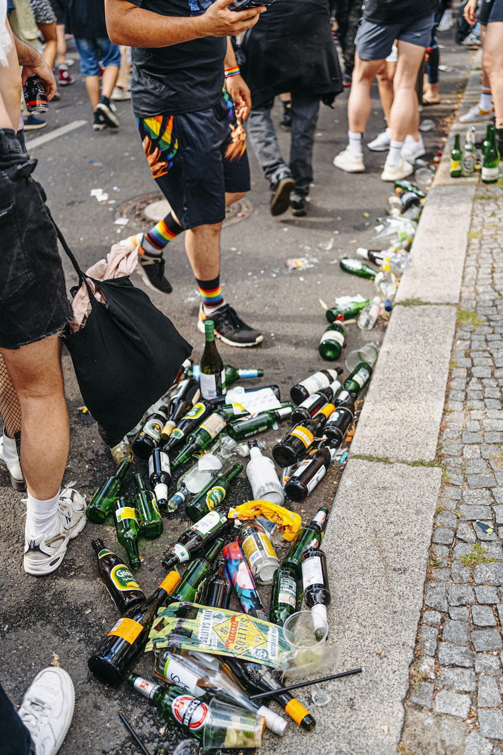 a group of people standing around a pile of beer bottles