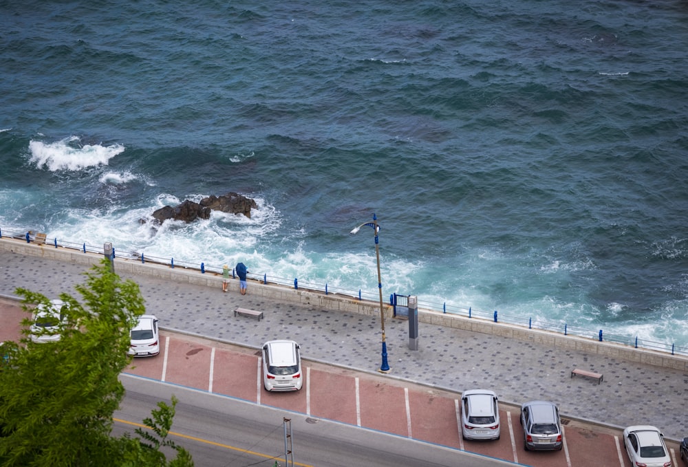 cars parked on the side of a road next to a body of water