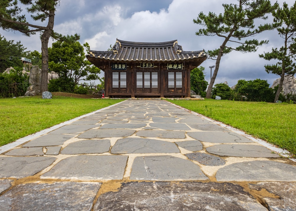 a stone walkway with a building on the side