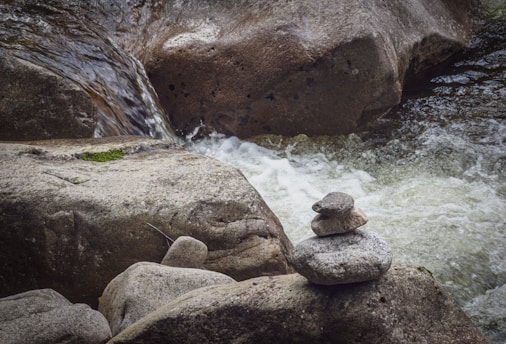 A serene rock cairn balanced on a smooth river stone in a natural setting