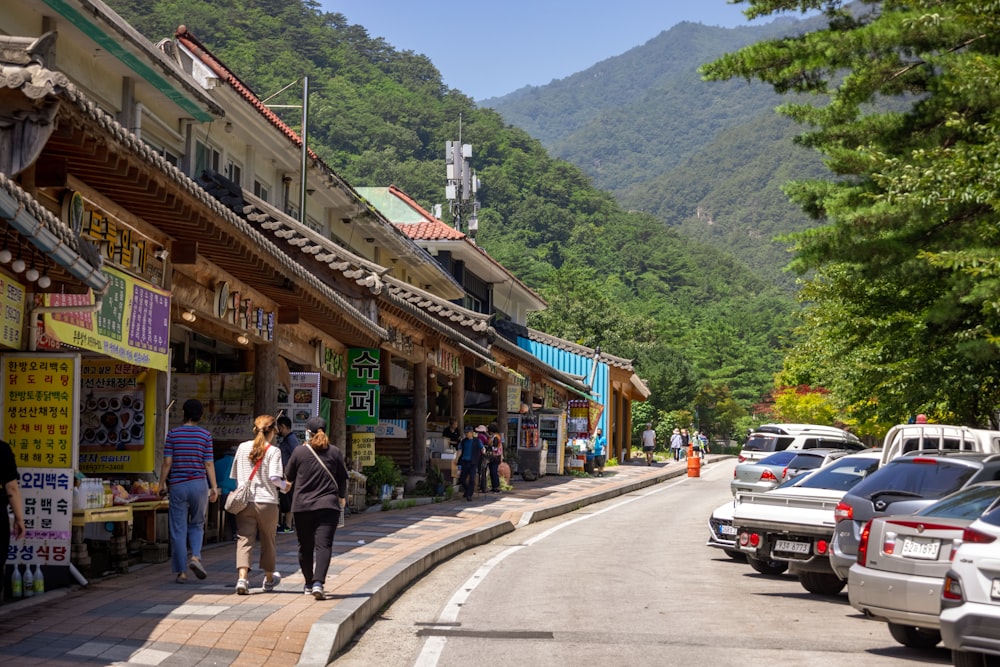 a street with cars and people on it and buildings on the side