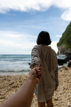 a person holding a baby on a beach