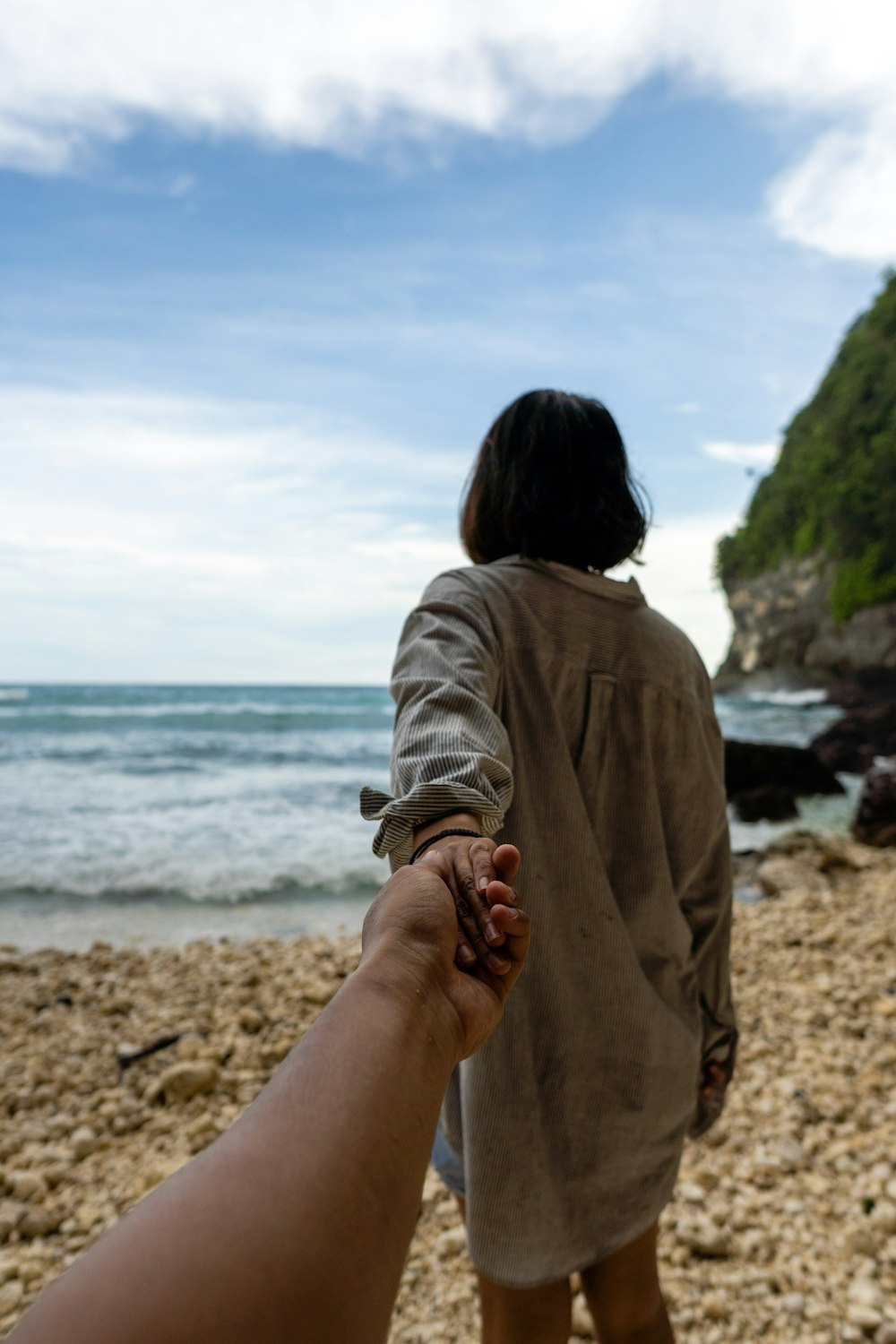 a person holding a baby on a beach