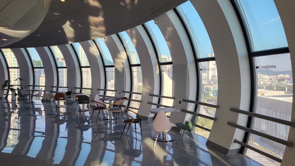 a room with a table chairs and a window with a view of a city