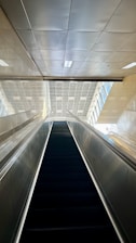 A skilled engineer inspecting a modern escalator system in a commercial building.