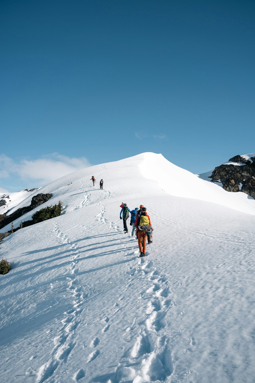 a group of people hiking up a snowy mountain