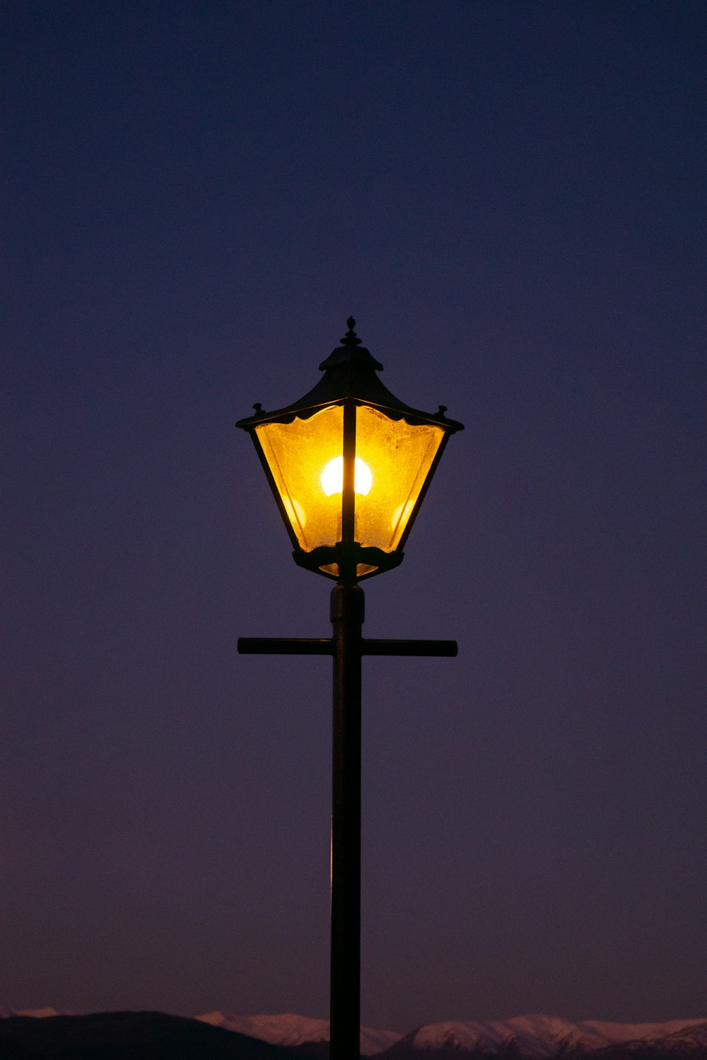 a street light with a mountain in the background