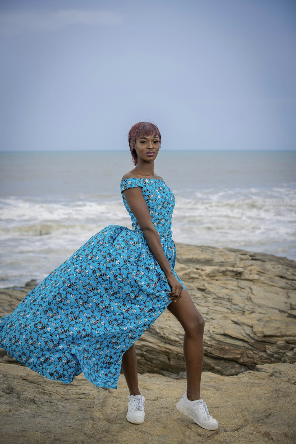 a man in a blue dress on a beach