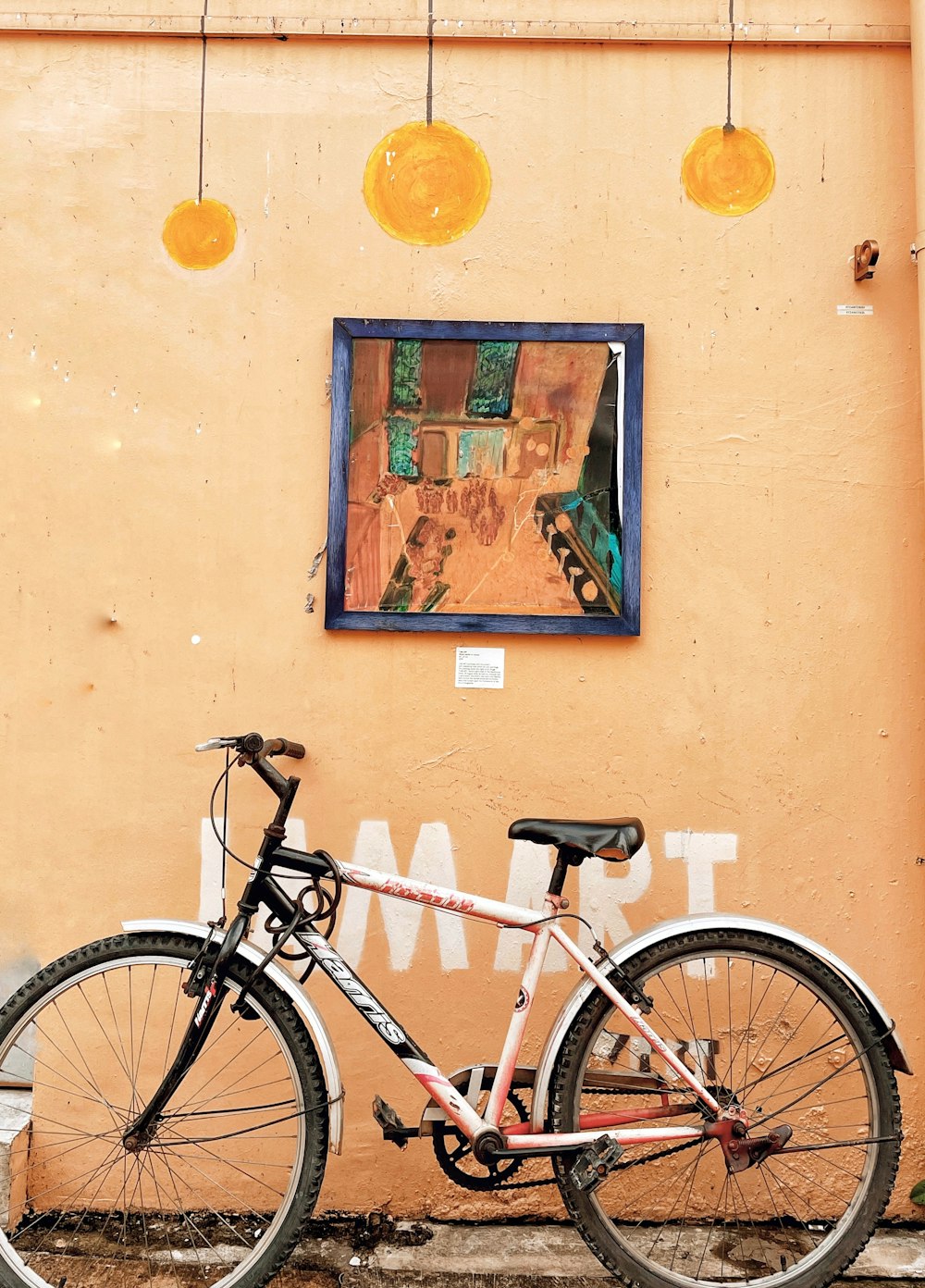 a bicycle is parked in front of a painting on a wall