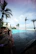 Man enjoying a sunny day by the pool of a luxury beach house.