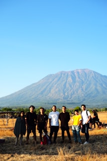 Group photo of PBLF Jharkhand team members collaborating outdoors, framed by lush greenery under a clear sky.