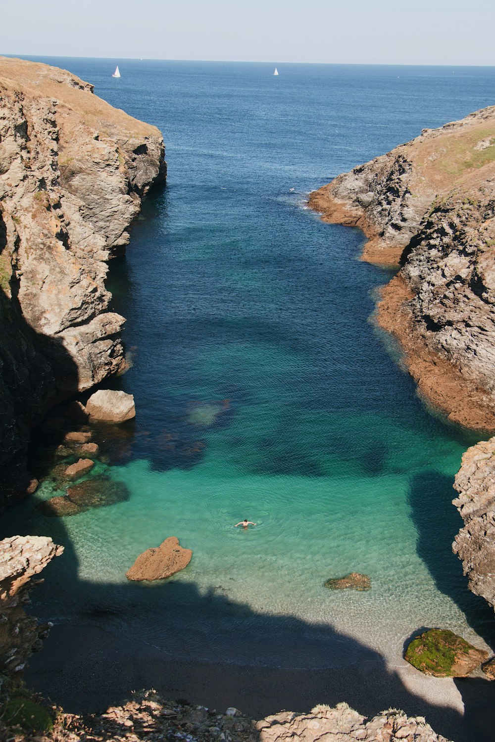 a body of water with rocks and a beach