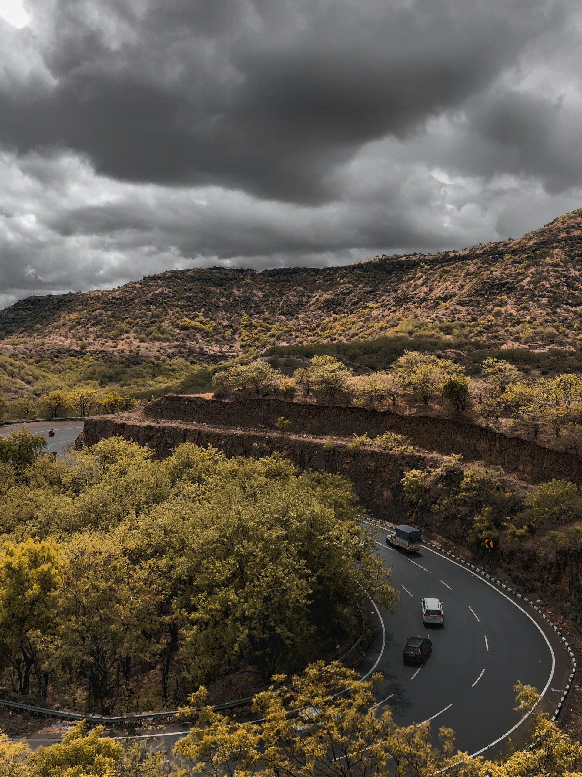 a road with cars on it and trees on the side