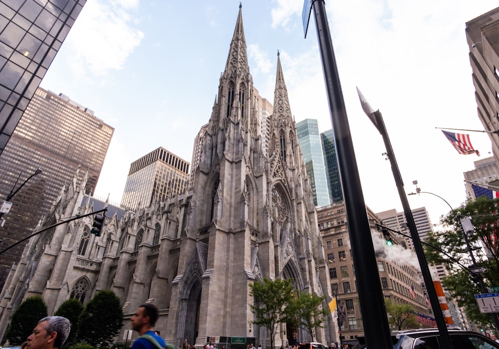 un grande edificio in pietra con torri con la Sagrada Família sullo sfondo