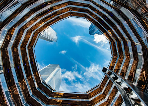 looking up at a blue sky through a window at a building
