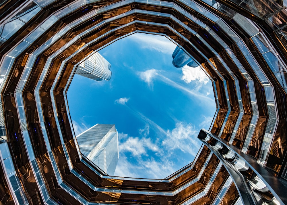 looking up at a blue sky through a window at a building