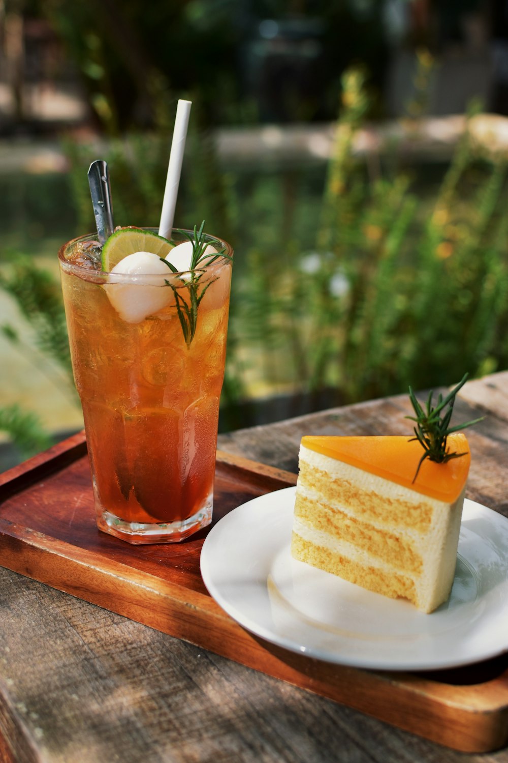 a glass of orange juice next to a slice of cake and a slice of orange