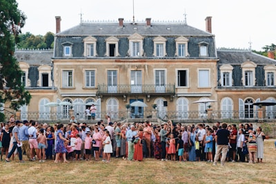 a group of people posing for a photo in front of a large building