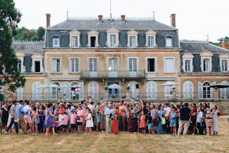 a group of people posing for a photo in front of a large building