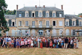 a group of people posing for a photo in front of a large building