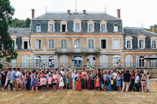 a group of people posing for a photo in front of a large building
