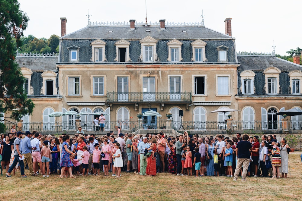 a group of people posing for a photo in front of a large building