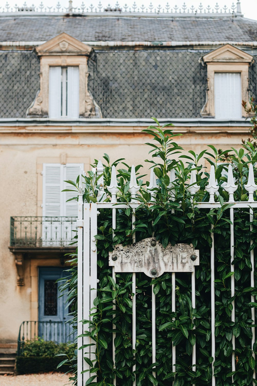 a house with a gate and a sign in front of it