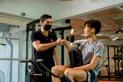 A professional handshake between a brand representative and a male fitness influencer in a gym setting.