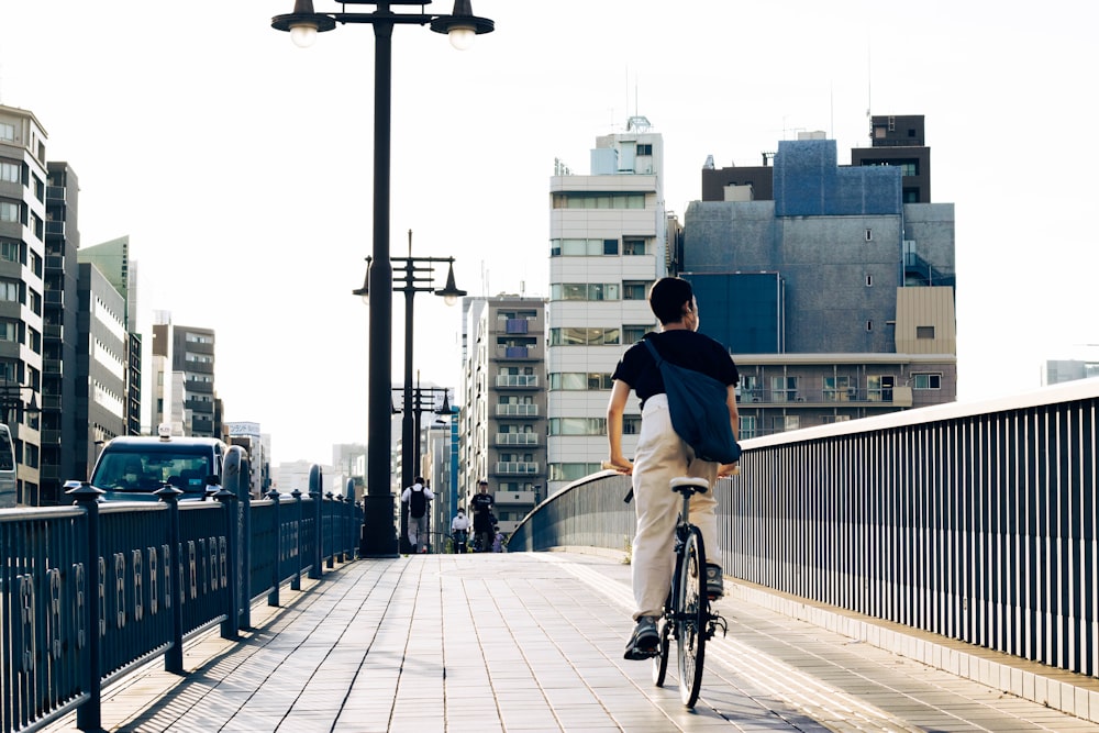 Un uomo che guida una bicicletta su un ponte