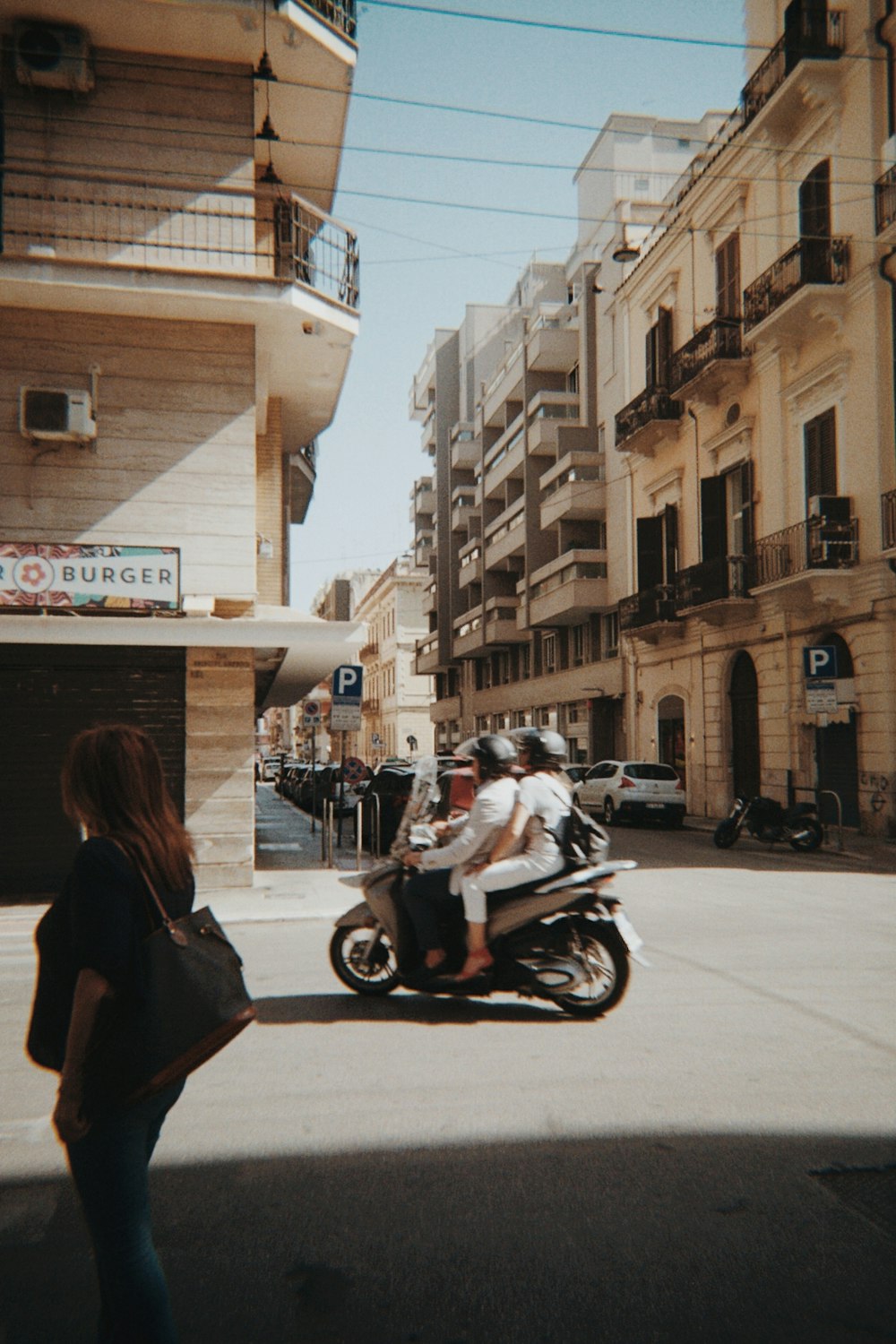 a group of people ride on a motorcycle down a street