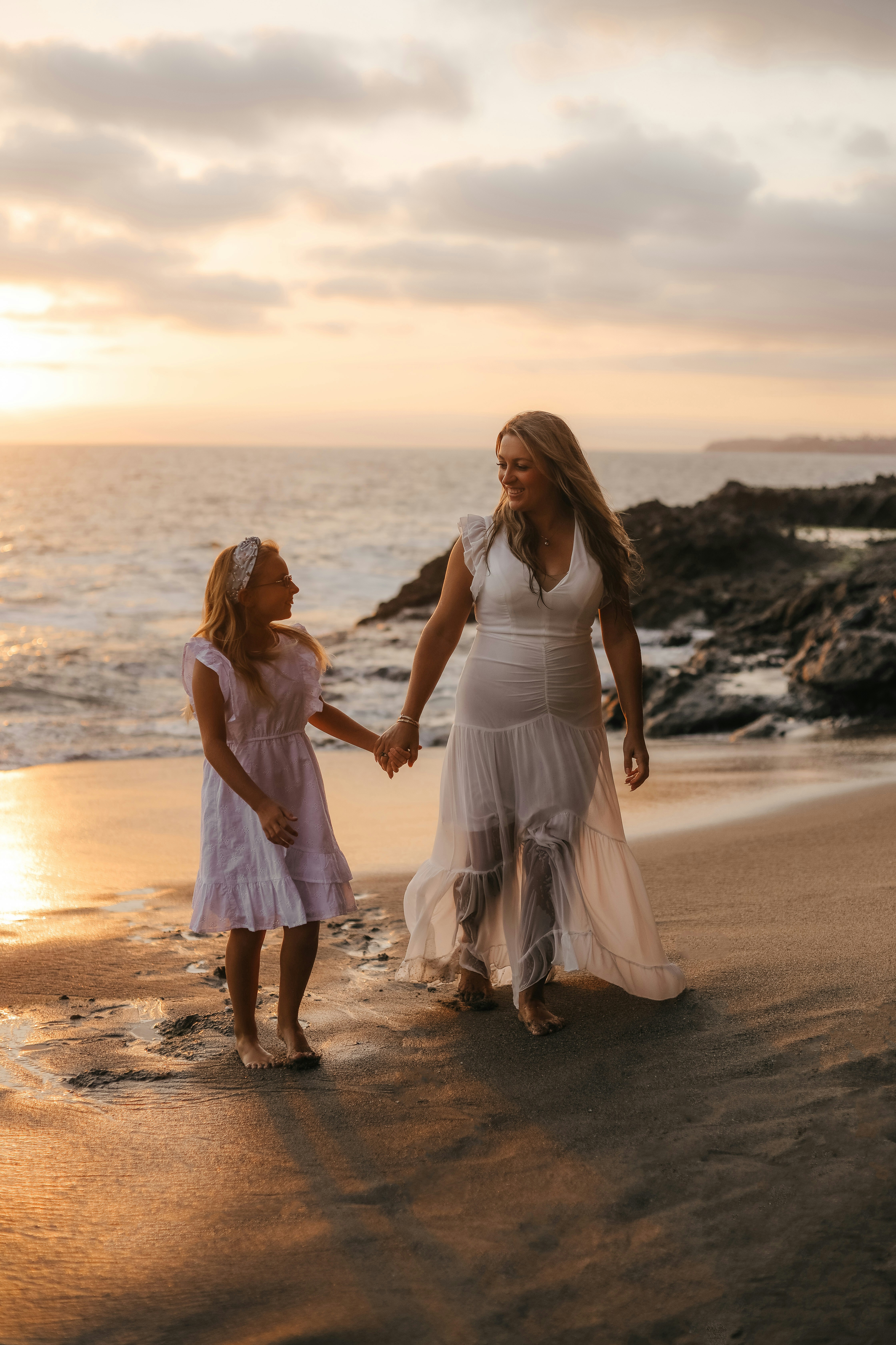 a couple of people that are standing in the sand on a beach