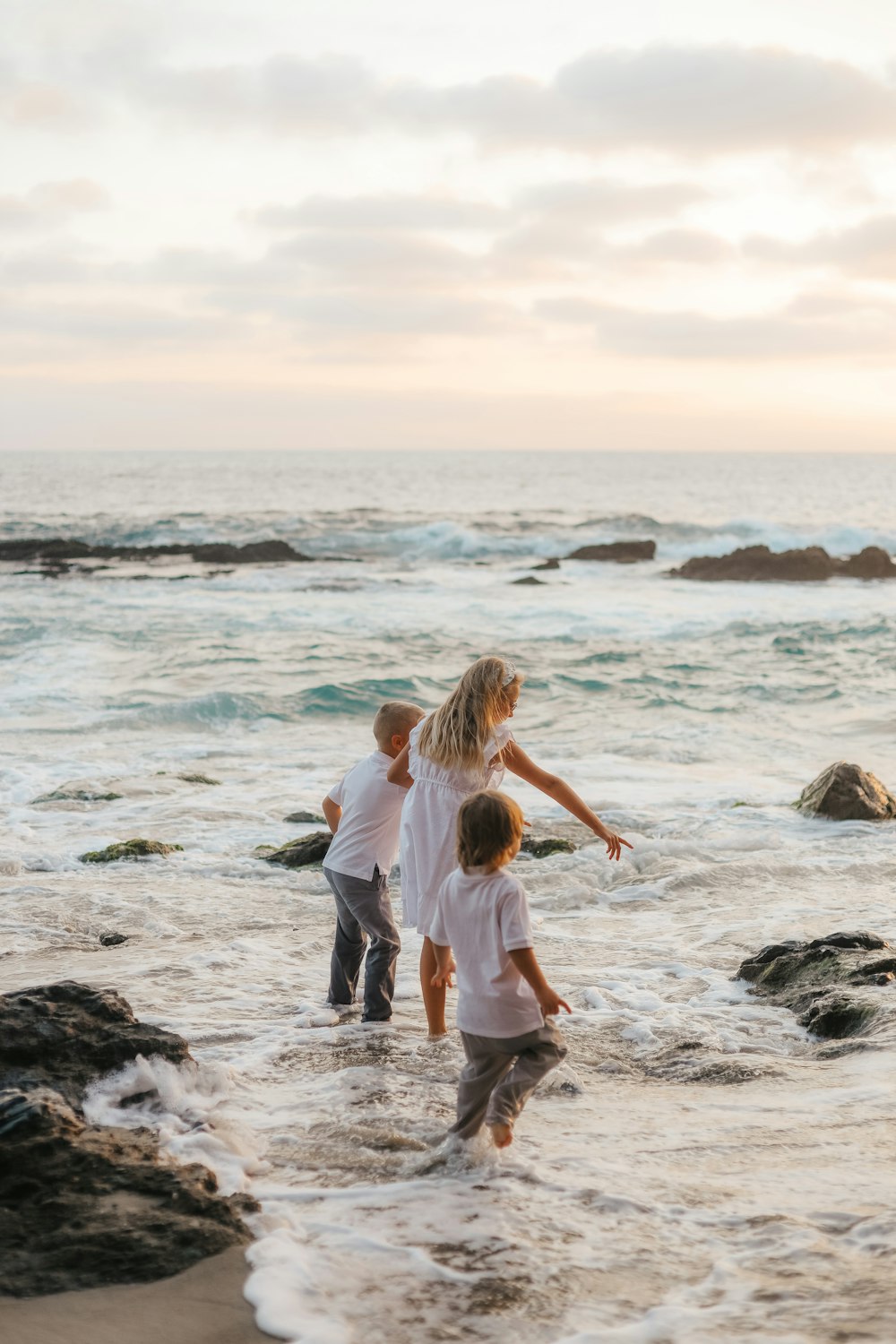 a group of people playing in the water at the beach