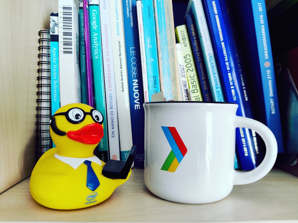 a mug next to a stack of books